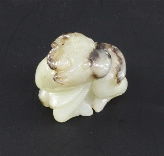 A Chinese white and black jade figure of a buffalo, in recumbent pose, 3.4cm